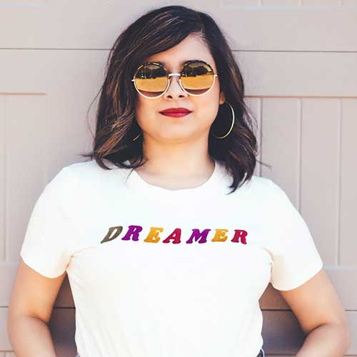 Dreamer printed in multi-colors on a white t-shirt